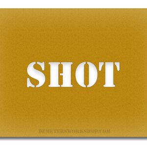 May include: Mustard-colored card with the word "SHOT" cut out in white, stencil-style letters. The website address DEMETERSWORKSHOP.COM is printed in small white letters at the bottom of the card.