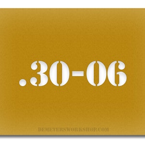 May include: Mustard-colored card with the white stencil text ".30-06". The website address DEMETERSWORKSHOP.COM is printed in white at the bottom of the card. The card has a textured surface.