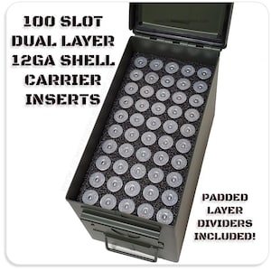 May include: An olive green metal ammo box with a black interior, holding numerous 12GA shell inserts. The box has a hinged lid and a front latch. Text on the box reads "100 SLOT DUAL LAYER 12GA SHELL CARRIER INSERTS" and "PADDED LAYER DIVIDERS INCLUDED!"