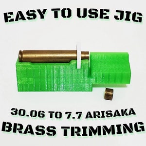 May include: A green 3D-printed jig with a brass cartridge and a small brass piece. The text "EASY TO USE JIG" is at the top, and "30.06 TO 7.7 ARISAKA BRASS TRIMMING" is at the bottom.