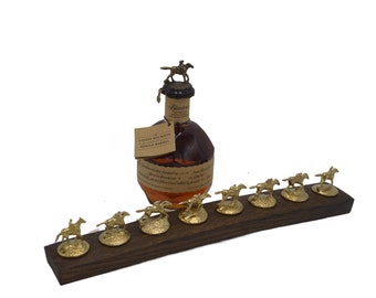 May include: A wooden display stand with ten miniature gold horses, each with a jockey, and a bottle of Evan Williams Bottled-in-Bond Kentucky Straight Bourbon Whiskey with a gold horse and jockey bottle stopper.