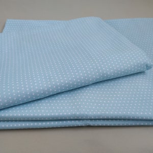May include: A stack of light blue fabric with a white polka dot pattern.
