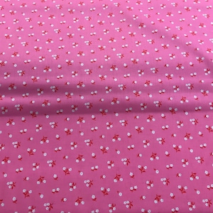 May include: Pink fabric with a white and red floral pattern. The fabric is a solid pink color with small white flowers and red stems.