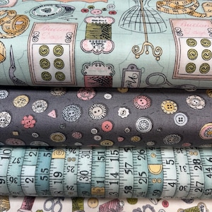 Peut inclure: Gros plan sur quatre rouleaux de tissu avec des motifs sur le thème de la couture. Le tissu supérieur est bleu clair avec des machines à coudre, des boutons et des bobines. Le second est gris avec des motifs de boutons et de fleurs. Le troisième a un motif de mètre ruban.
