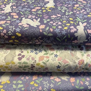 Puede incluir: Primer plano de tres muestras de tela con un estampado floral y de conejos. Las muestras superior e inferior son de color púrpura intenso, mientras que la muestra del medio es blanquecina. El estampado incluye flores rosas, amarillas y azules.