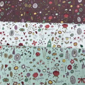 Może przedstawiać: Trzy próbki tkaniny z białym tłem i różnorodnymi kolorowymi kwiatami i roślinami. Tkanina ma kapryśny, ręcznie rysowany styl. Nazwy kwiatów są napisane na tkaninie, w tym "Kosmos", "Tulipan", "Banksia", "Mak", "Hortensja", "Waratah", "Statice", "Fiołek", "Malwa", "Gwiazdnica" i "Larkspur".