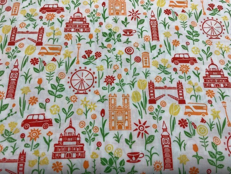 May include: White fabric with a repeating pattern of red and orange London landmarks, including Big Ben, the London Eye, and a double-decker bus. The pattern also includes red and orange flowers and green leaves.