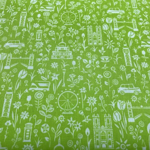 May include: Green fabric with a white repeating pattern of London landmarks, including Big Ben, the London Eye, and a double-decker bus. The pattern also includes flowers, teacups, and other small details.