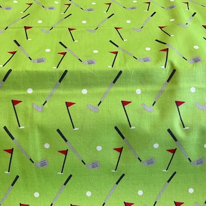May include: Lime green fabric featuring a repeating pattern of golf clubs, red flags, and white golf balls. The golf clubs are grey with black handles. The flags are red with white poles. The golf balls are white.