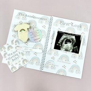May include: A white baby onesie with a rainbow design is displayed on a white background with a rainbow and star pattern. The text "The Announcement" is at the top of the page. A pregnancy test with a positive result is visible in the lower left corner. A small tag with the text "Sometimes we are the rainbow.  You make the storm. And the heavens know you deserved every bit of the dreams we are now living." is attached to the onesie.