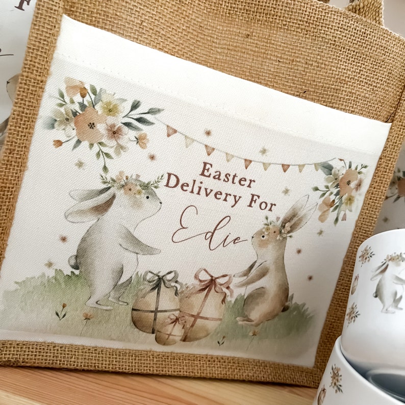 May include: A burlap tote bag with a white fabric insert featuring two bunnies, flowers, and the text "Easter Delivery For Edie".