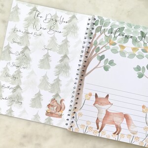 K&ouml;nnte beinhalten: Ein Baby-Erinnerungsbuch mit einer Aquarell-Illustration eines Fuchses in einer Waldlandschaft. Der Einband zeigt den Text "Willkommen Zuhause" mit einer Fahnenkette. Die Innenseite hat eine Aquarell-Illustration eines Eichh&ouml;rnchens in einer Waldlandschaft mit dem Text "Der Tag, an dem du geboren wurdest".