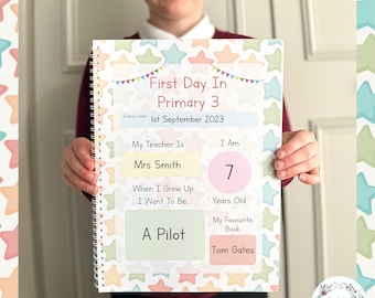 May include: A colorful notebook with a star pattern and the text "First Day In Primary 3" and "1st September 2023". The notebook has sections for the student to fill in their teacher's name, age, favorite book, and what they want to be when they grow up.
