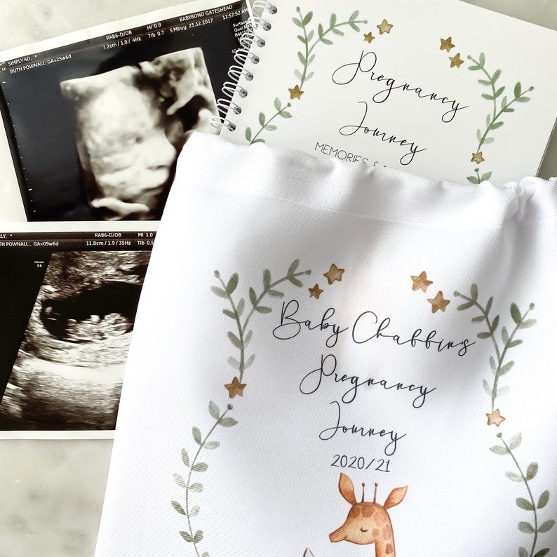 May include: A white canvas bag with a gold and green floral design and the text "Baby Chabbing Pregnancy Journey 2020/21". A small illustration of a giraffe is at the bottom of the bag.