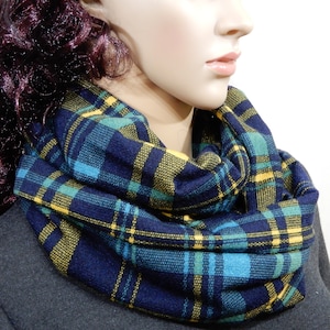 May include: A navy blue infinity scarf with yellow and teal plaid pattern.