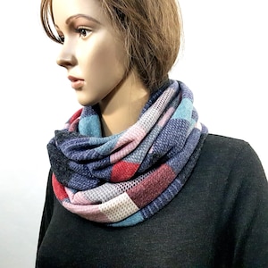 May include: A blue, pink, red and white infinity scarf with a checkered pattern.