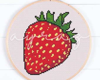 May include: A red and green cross-stitch embroidery of a strawberry in a wooden embroidery hoop.
