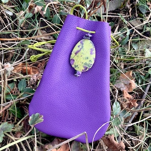 May include: A purple leather pouch with a drawstring closure and a green and purple stone pendant.