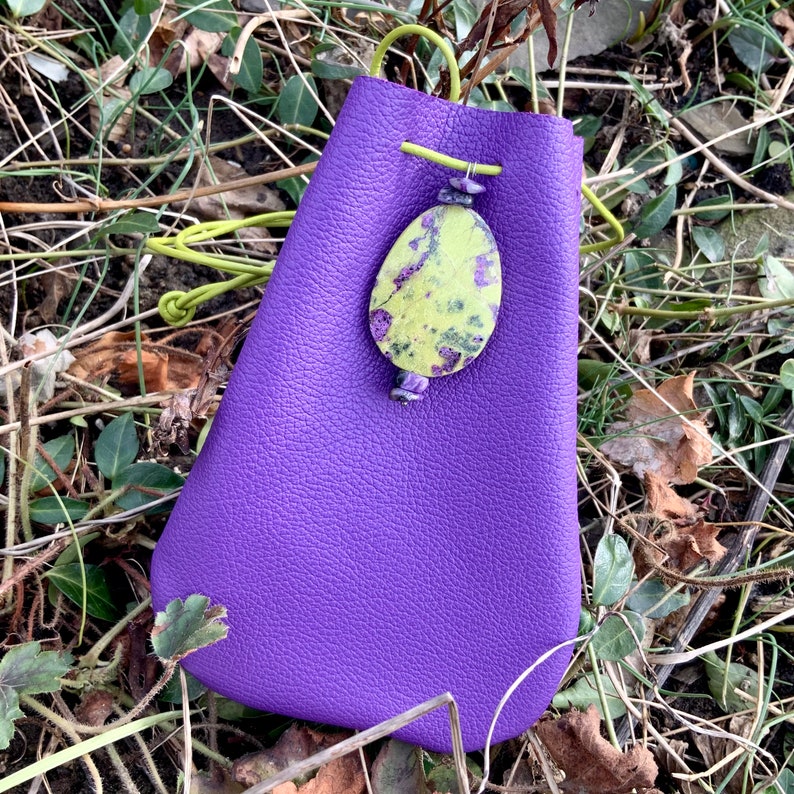 May include: A purple leather pouch with a drawstring closure and a green and purple stone pendant.