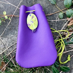 May include: A purple leather drawstring bag with a green and yellow floral patterned closure.