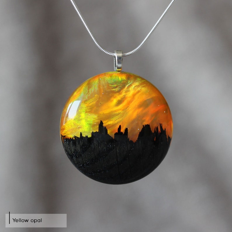 Round pendant handmade with yellow lab-created opal, wood and resin. Opals iridescent colors shift from green, yellow & orange, and the wood texture gives the impression of a mountain peaks.