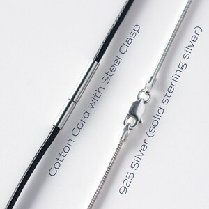 May include: Close-up of two necklace chains. One is a black cotton cord with a steel clasp. The other is a 925 silver chain. Text on the image reads "Cotton Cord with Steel Clasp" and "925 Silver (solid sterling silver)".