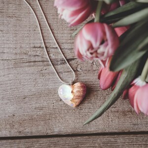 Heart shaped pendant handmade with white lab-created opal, burl wood and resin. Opals iridescent colors shift from white, blue, green, orange, pink & more.
