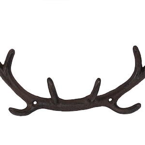 May include: A cast iron antler wall hook with a dark brown finish. The hook has five points for hanging items.