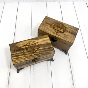 May include: Two wooden boxes with engraved images of a twenty-sided die and a sword. The top box reads "One Kind" and the bottom box reads "For My Natural 20".