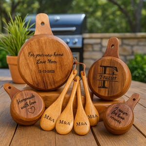 May include: A collection of wooden kitchen utensils, including measuring cups and spoons. The measuring cups have handles and engraved text: "For your new home Love Mom 11-12-2025", "Homemade with love", and "A recipe for love forever". The spoons are engraved with "M&A".