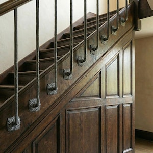 May include: A wooden staircase with dark brown steps and paneling. The staircase features decorative metal balusters with ornate detailing. The design is classic and elegant, with a focus on craftsmanship and traditional style.