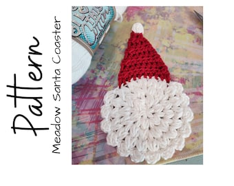 May include: A handmade crochet Santa Claus coaster with a red hat and white beard. The coaster is round and has a textured appearance. The word "Pattern" is written vertically in black on the left side of the image.