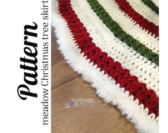 Puede incluir: Patrón de falda de árbol de Navidad de ganchillo en rojo, blanco y verde con un ribete de piel sintética blanca. El patrón se llama "Meadow Christmas Tree Skirt".