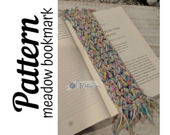May include: A colorful crocheted bookmark with a fringe on the bottom. The bookmark is in a book with the text "Iron the Sprinkles Work Is Worth It" visible.