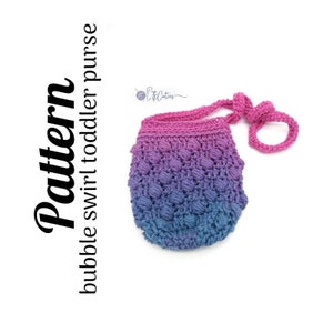 May include: A crocheted bubble swirl toddler purse with a pink and blue ombre color scheme. The purse has a long strap and is perfect for carrying small toys or treasures.