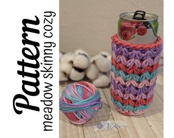 May include: A crochet pattern for a skinny can cozy, with a ball of yarn in pink, blue, and purple colors. The pattern is called "Meadow Skinny Cozy".