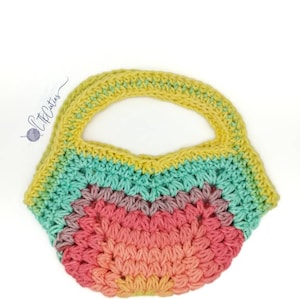 May include: A crocheted rainbow tote bag with a yellow handle. The bag is made with a variety of colors, including pink, orange, yellow, green, and blue.