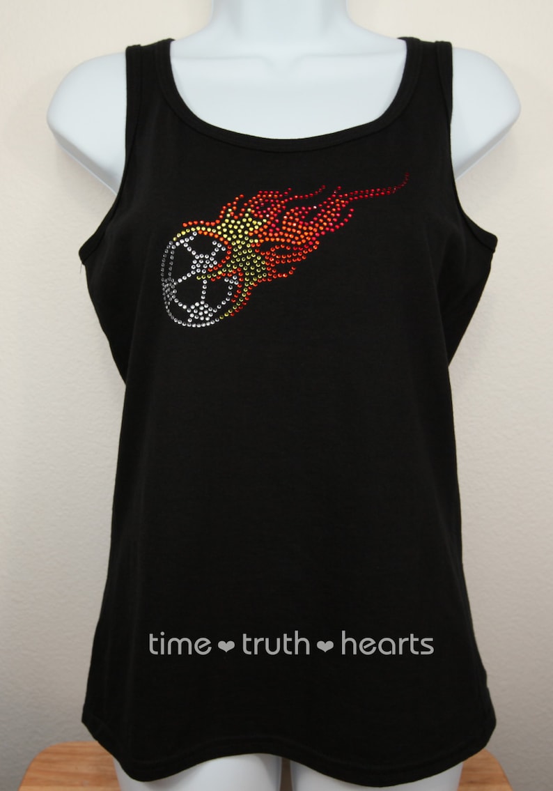 Puede incluir: Camiseta negra de tirantes con un dise&ntilde;o de bal&oacute;n de f&uacute;tbol y llama de pedrer&iacute;a. El texto "time &hearts; truth &hearts; hearts" est&aacute; impreso en la parte inferior de la camiseta.