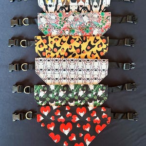 May include: Set of 7 dog bandanas with various patterns featuring bull terrier faces. The bandanas are black, white, red, yellow, green, and floral. Each bandana has a black adjustable strap with a plastic buckle.
