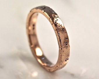 Op de afbeelding: Een roségouden ring met een getextureerde afwerking.