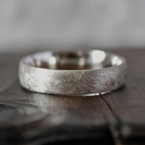 May include: A silver wedding band with a brushed finish.