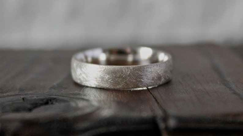May include: A silver wedding band with a brushed finish.