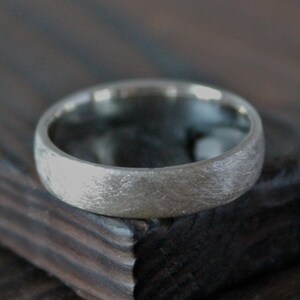 May include: A silver wedding band with a brushed finish.