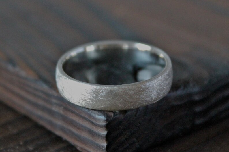 May include: A silver wedding band with a brushed finish.