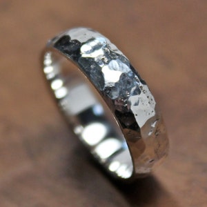 May include: A silver hammered band ring with a textured finish.