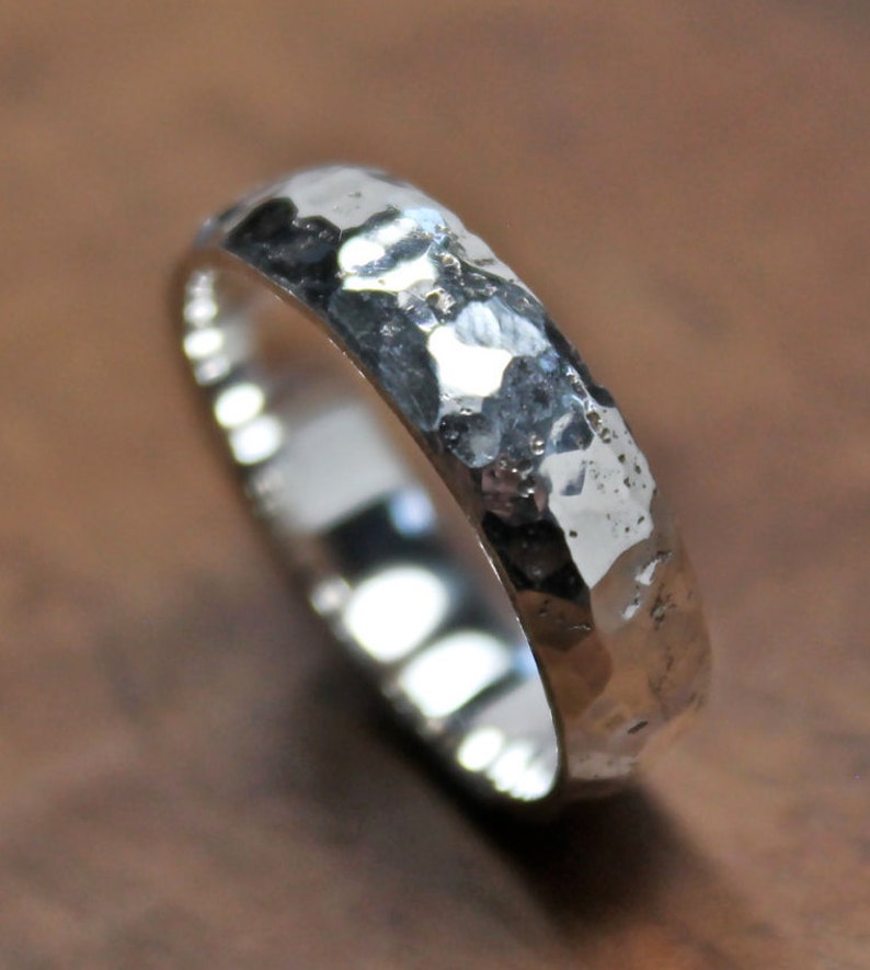 May include: A silver hammered band ring with a textured finish.