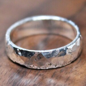 May include: A silver hammered band ring with a textured finish.