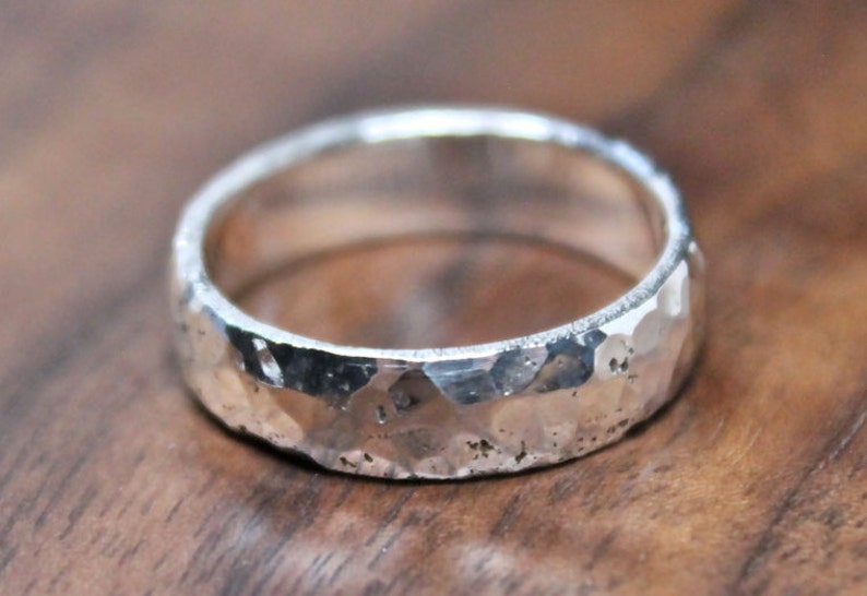 May include: A silver hammered band ring with a textured finish.