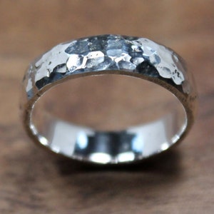 May include: A silver hammered band ring with a smooth, polished interior.