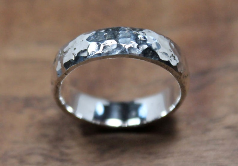 May include: A silver hammered band ring with a smooth, polished interior.